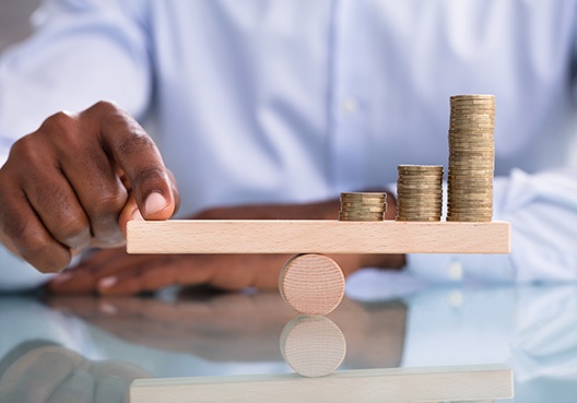 A man balancing coins on a scale A man balancing coins on a scale